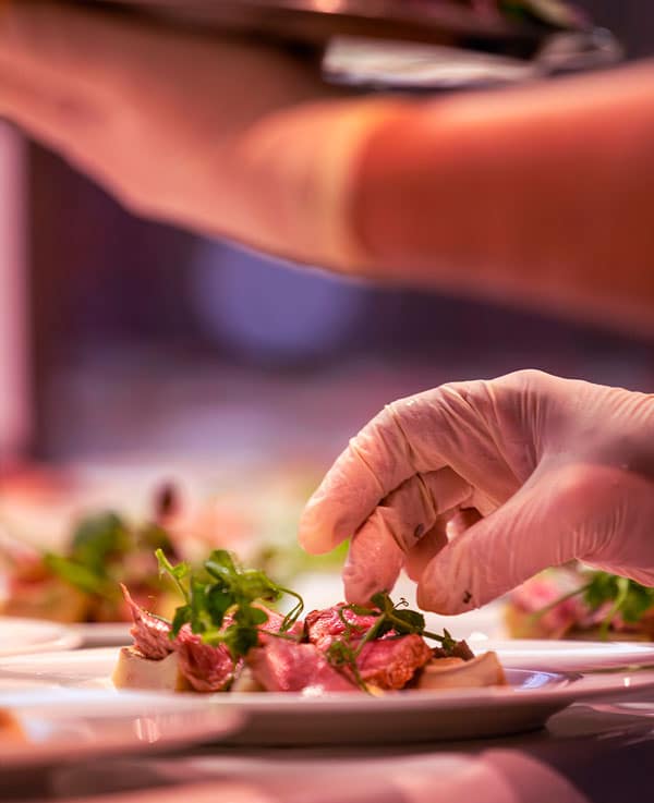 Nahaufnahme wie eine Person ein Gericht anrichtet